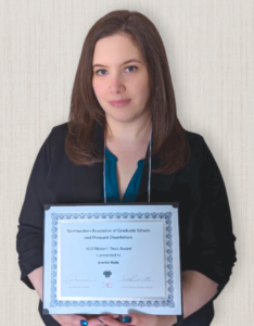 Jennifer Robb holding her certificate from NAGS. The certificate reads, "Northeastern Association of Graduate Schools and Proquest Dissertations 2023 Masters Thesis Award is presented to Jennifer Robb".